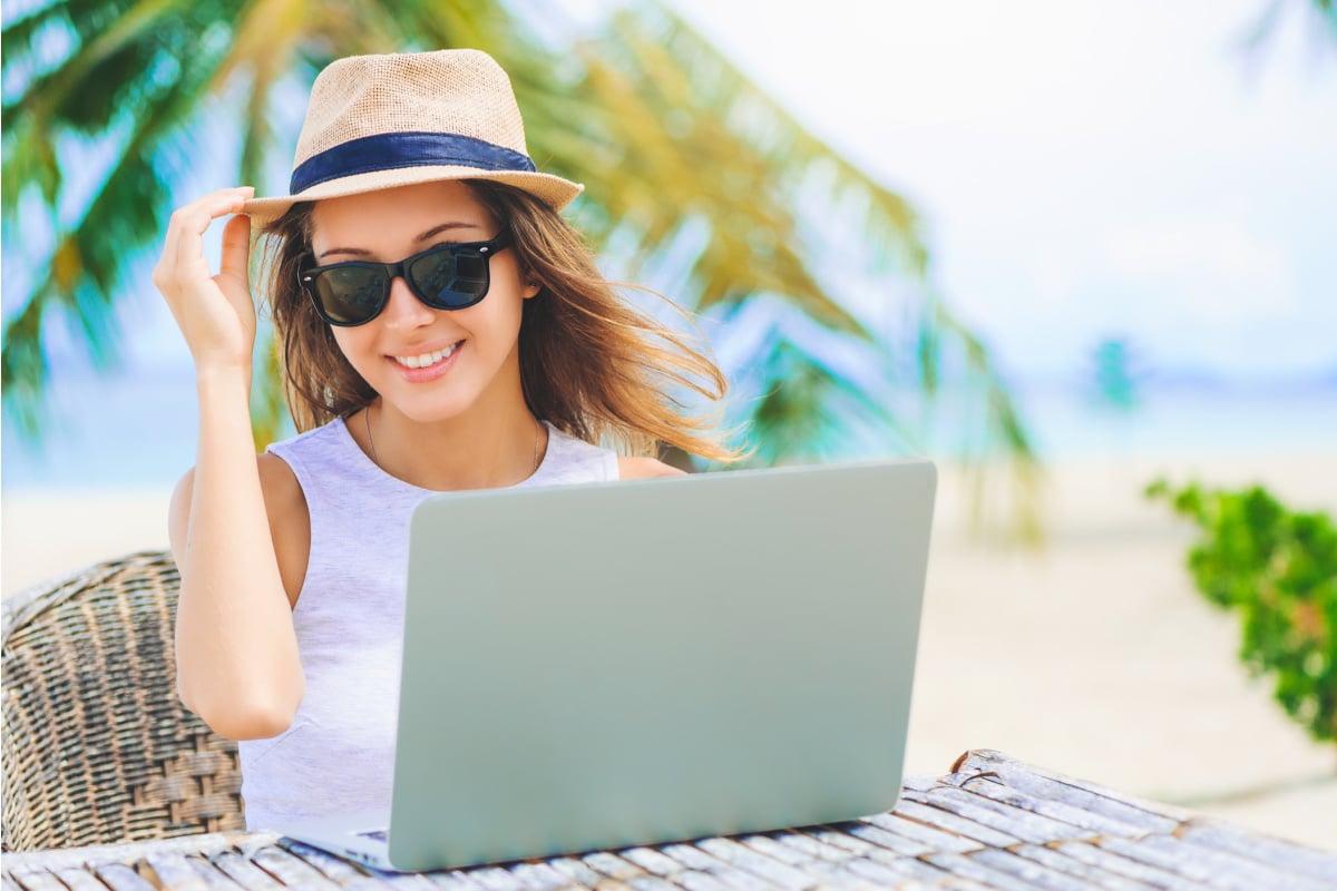 Digital nomad working on palm tree-lined beach in Caribbean